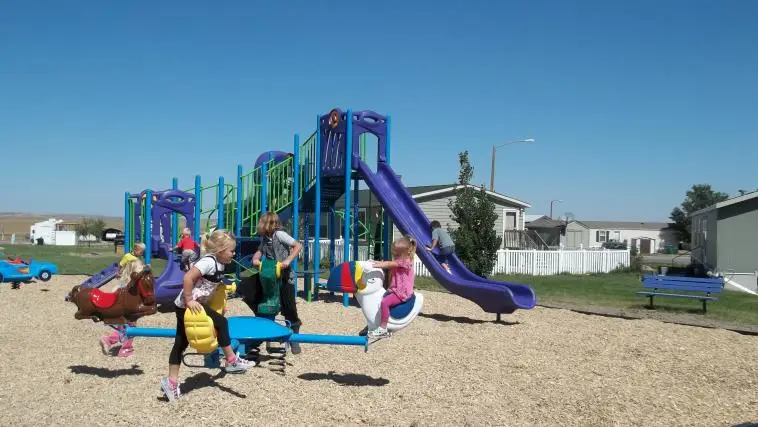 Community playground area at Cottonwood Mobile Home Park with slides and open space in Wright Wyoming